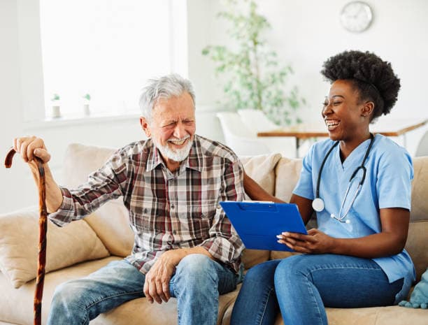 nurse laughing with elderly man