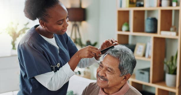 nurse combing elderly man's hair